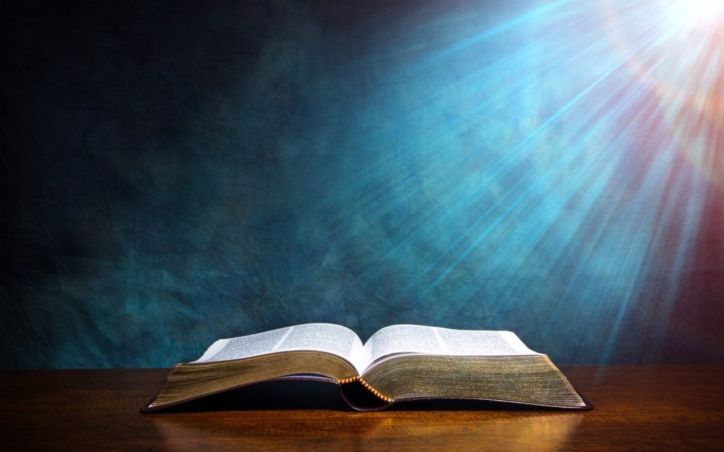 An open bible with rays of light by which we know the Apostles Doctrine